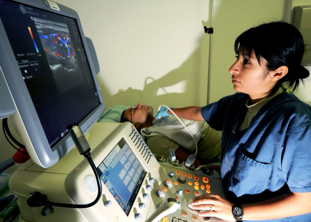 Profissional realizando ultrassonografia da tireoide